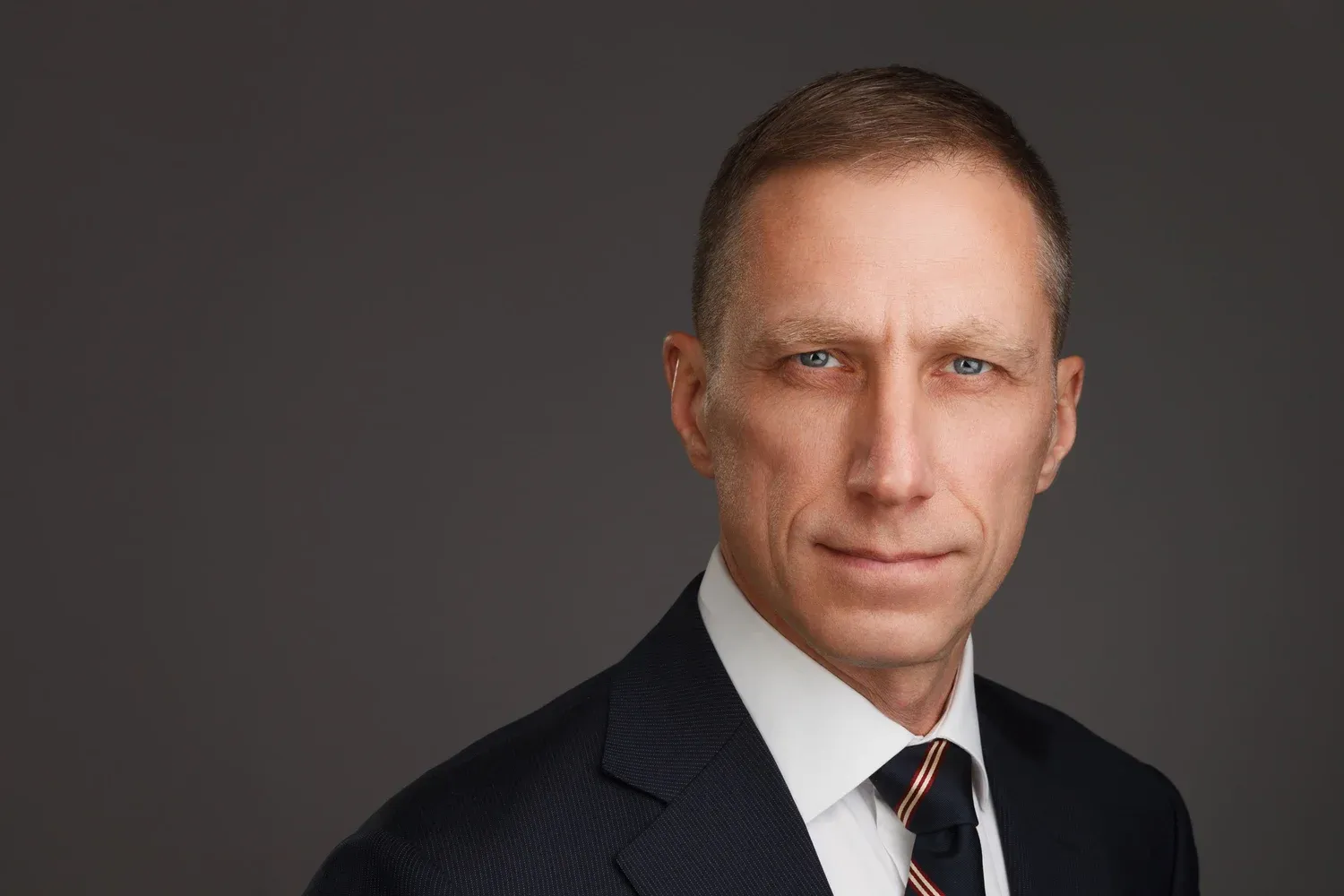 Executive posing confidently for a professional headshot in a well-lit studio setting